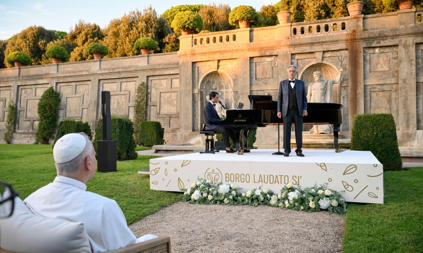 Zwei Männer stehen auf einer Bühne in einem Garten