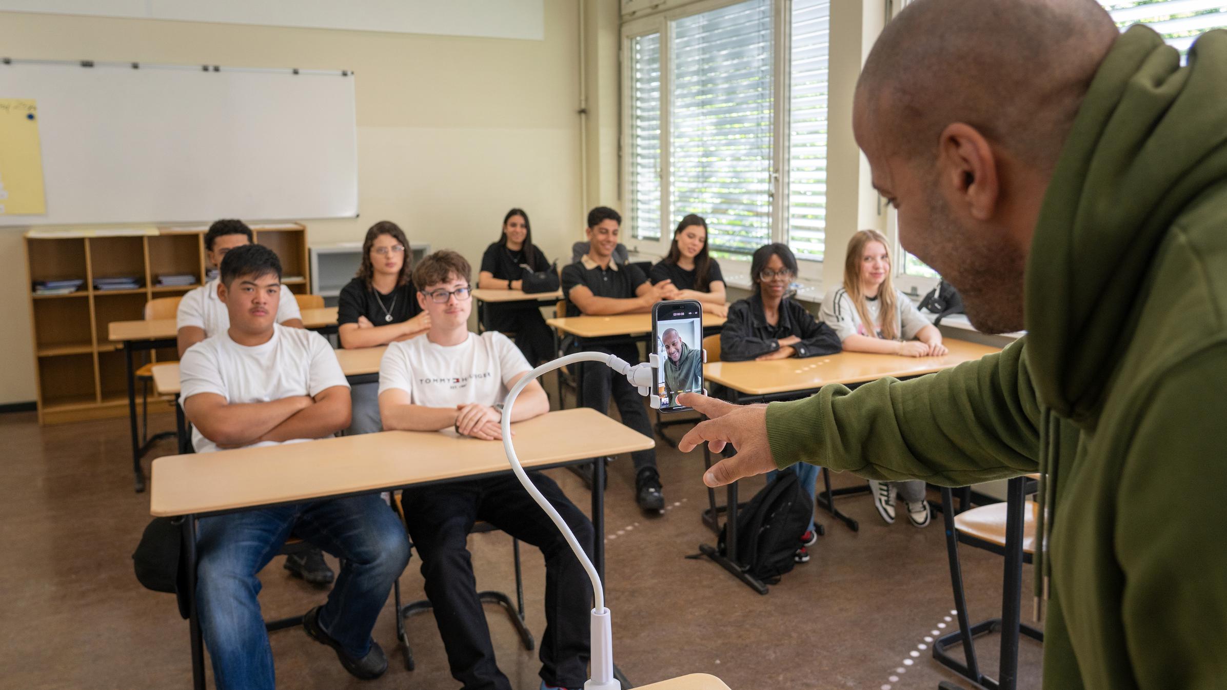 Ein Lehrer filmt sich selbst beim Unterrichten mit dem Mobiltelefon.