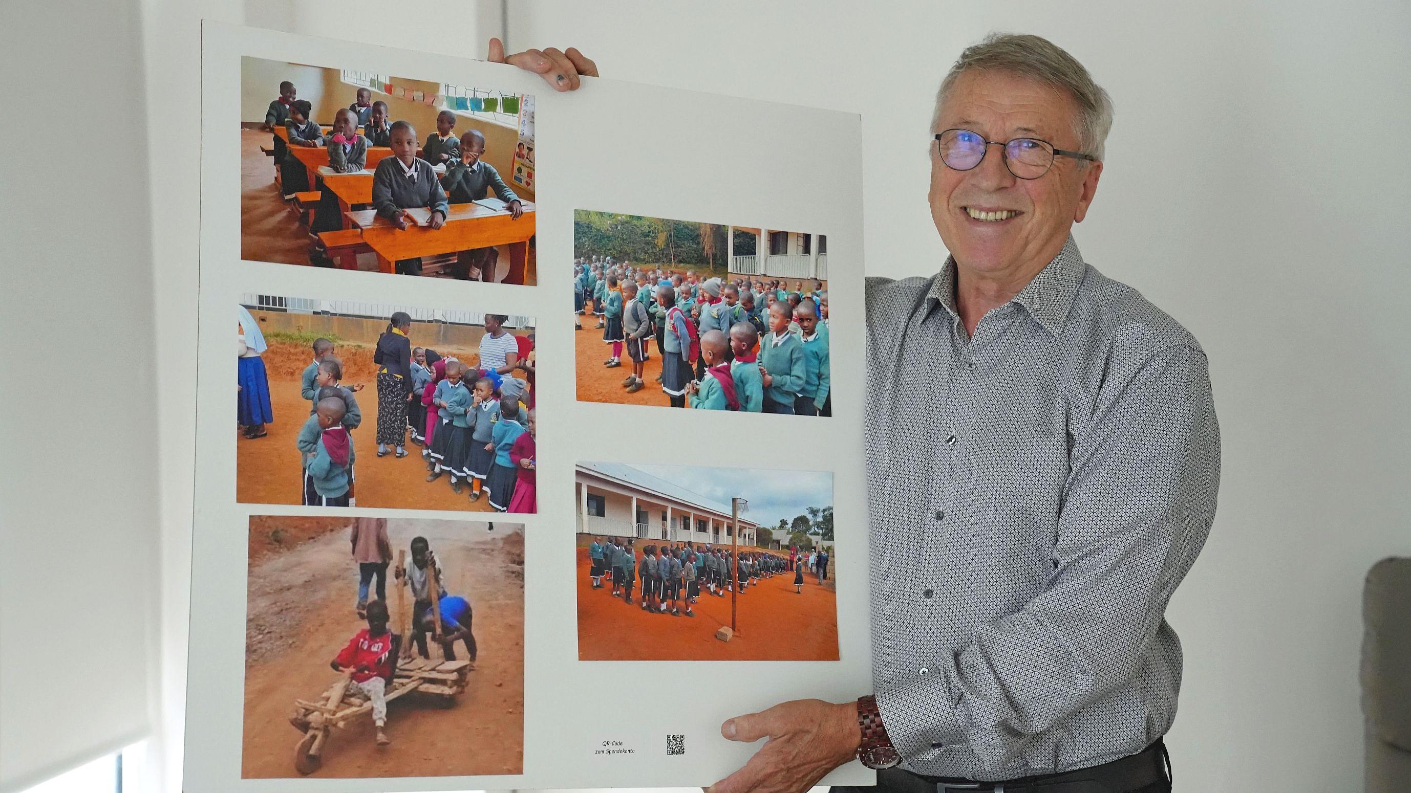 Eduard Kimmlingen zeigt ein Plakat mit Fotos der Projekte