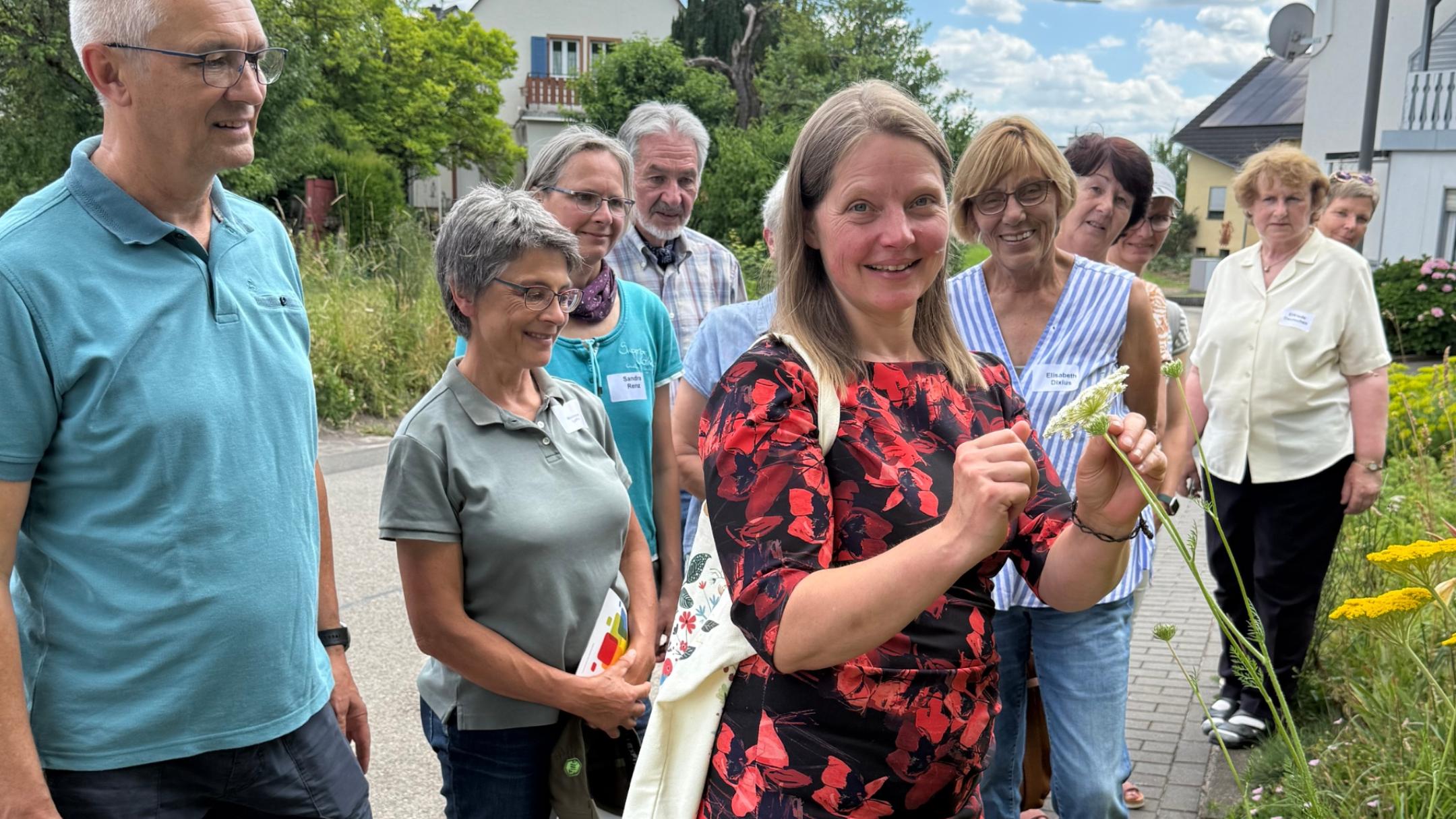 Referentin Annette Fehrholz zeigt den Teilnehmenden Pflanzflächen in Föhren vor.