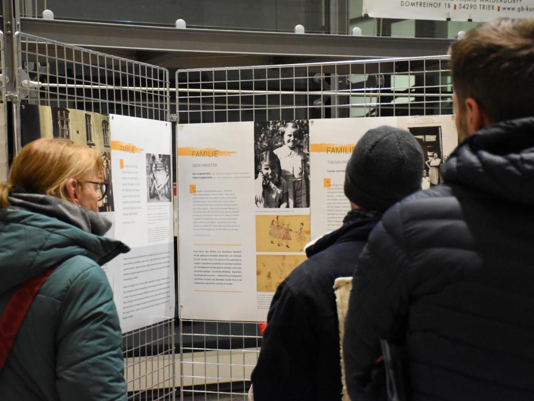 Besucher betrachten Infotafeln der Ausstellung.