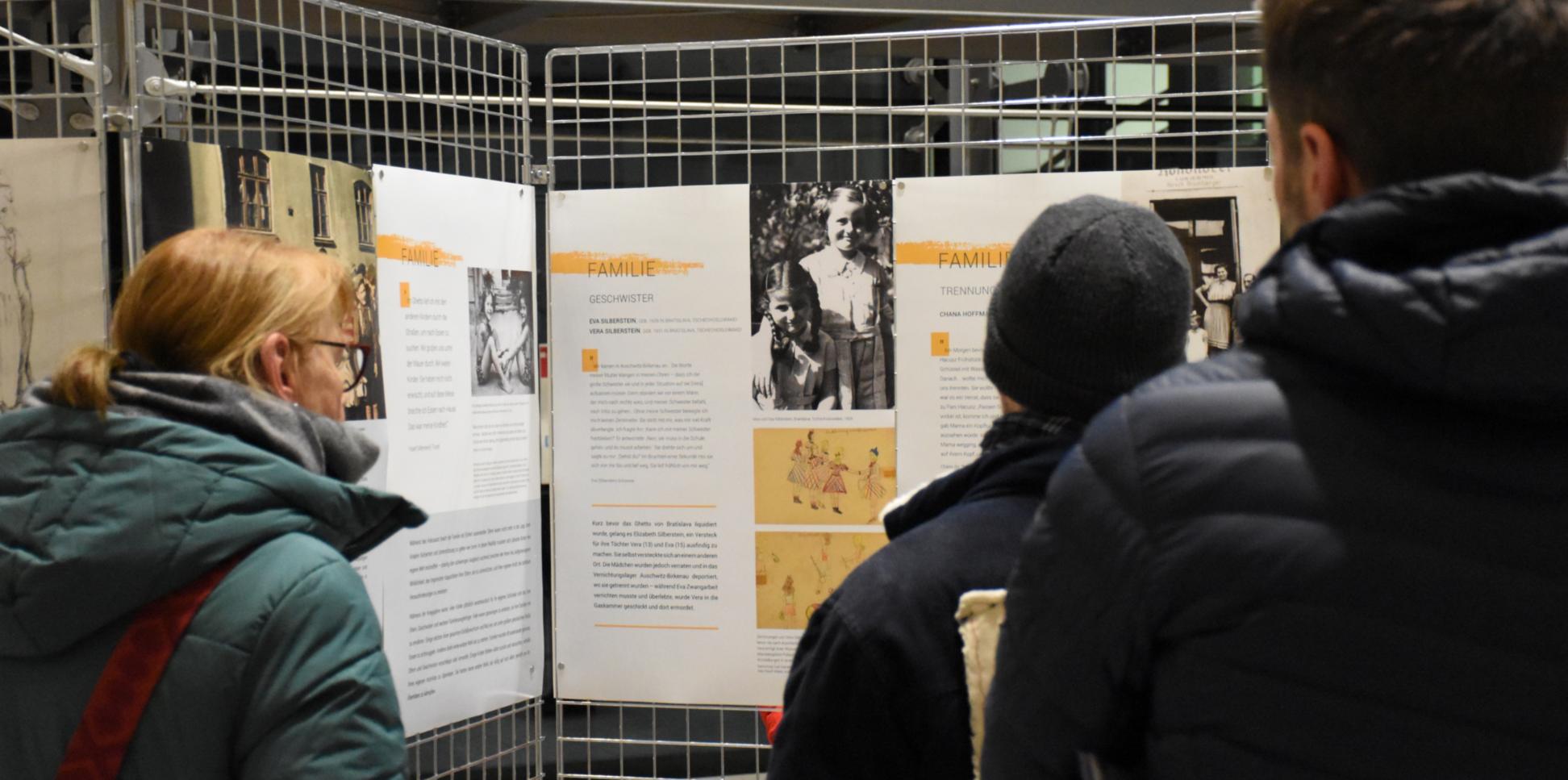 Besucher betrachten Infotafeln der Ausstellung.