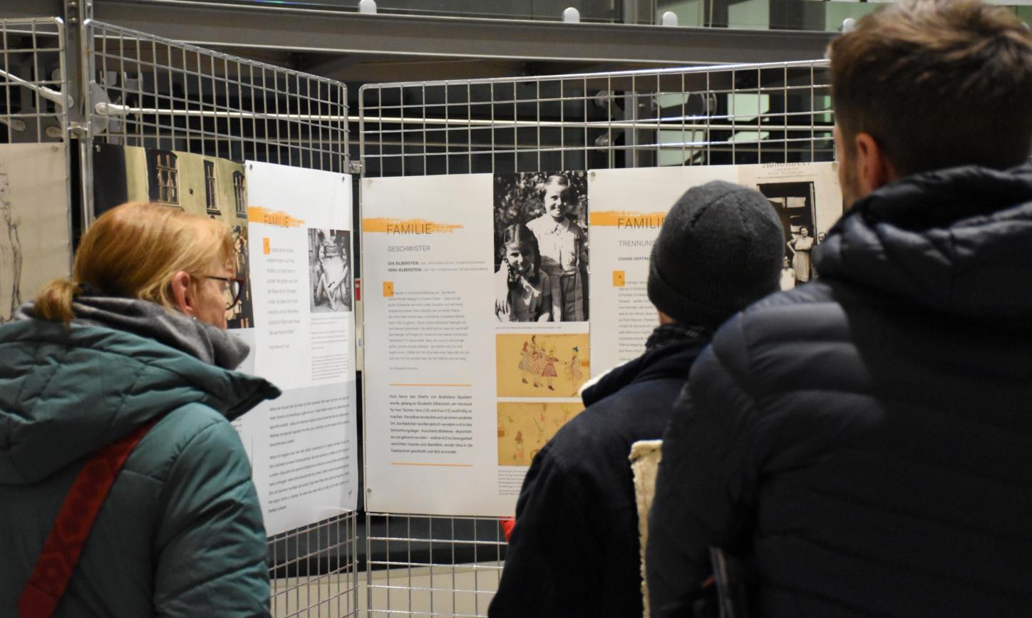 Besucher betrachten Infotafeln der Ausstellung.