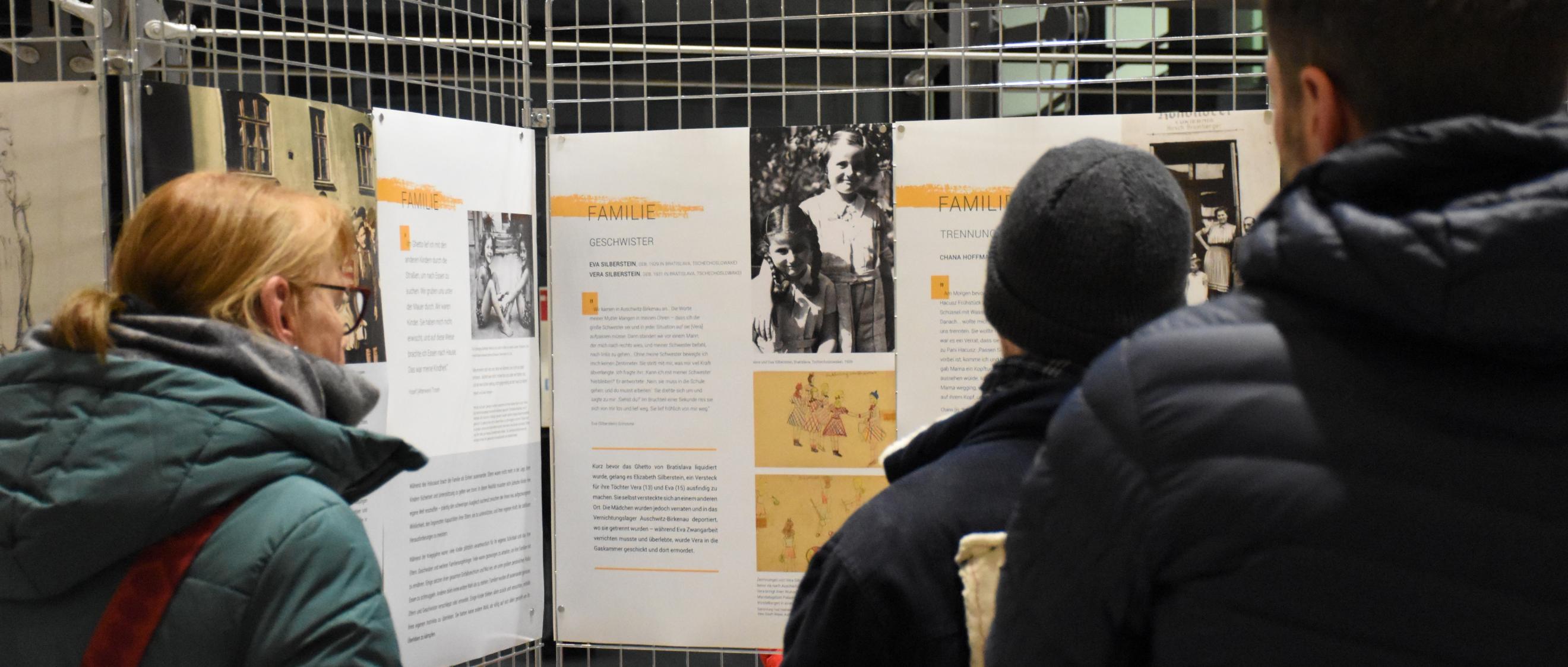 Besucher betrachten Infotafeln der Ausstellung.