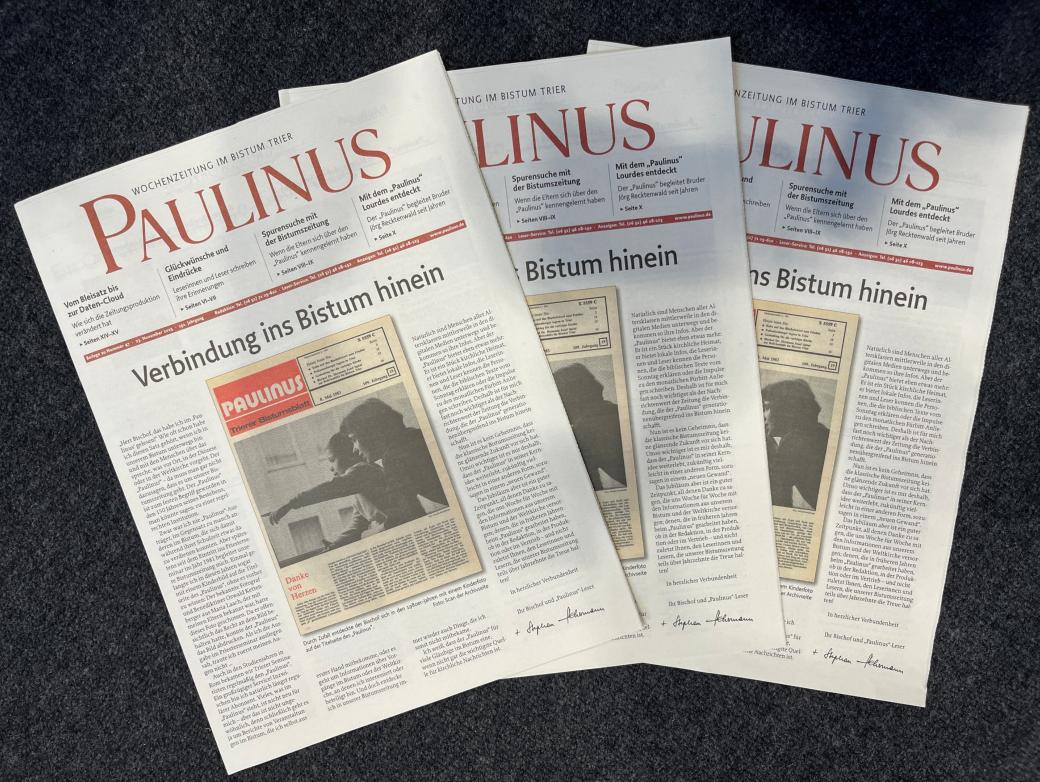 Drei Ausgaben einer Zeitung liegen gefächert übereinander