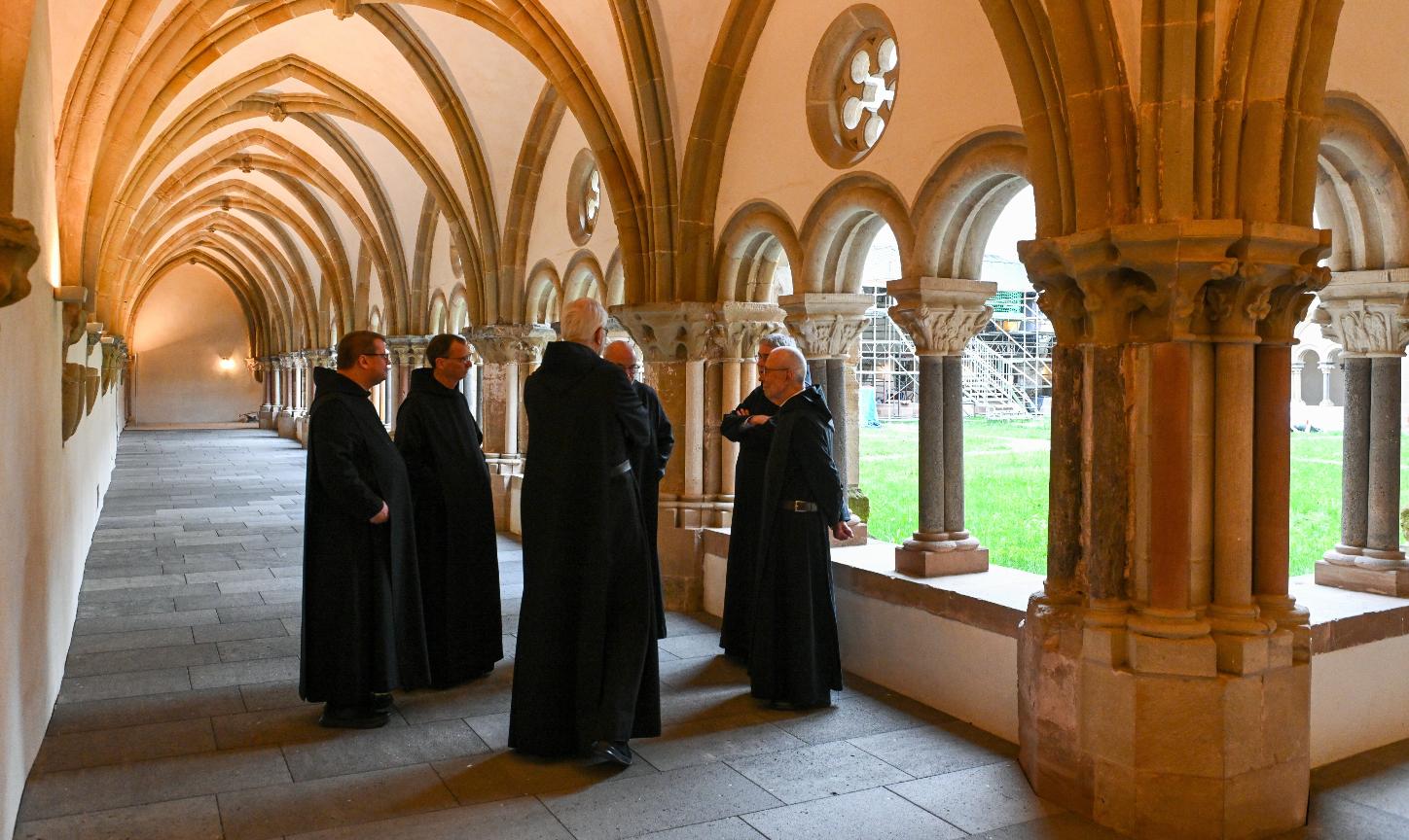 Mönche stehen im Kreuzgang der Benediktinerabtei Sankt Matthias in Trier.