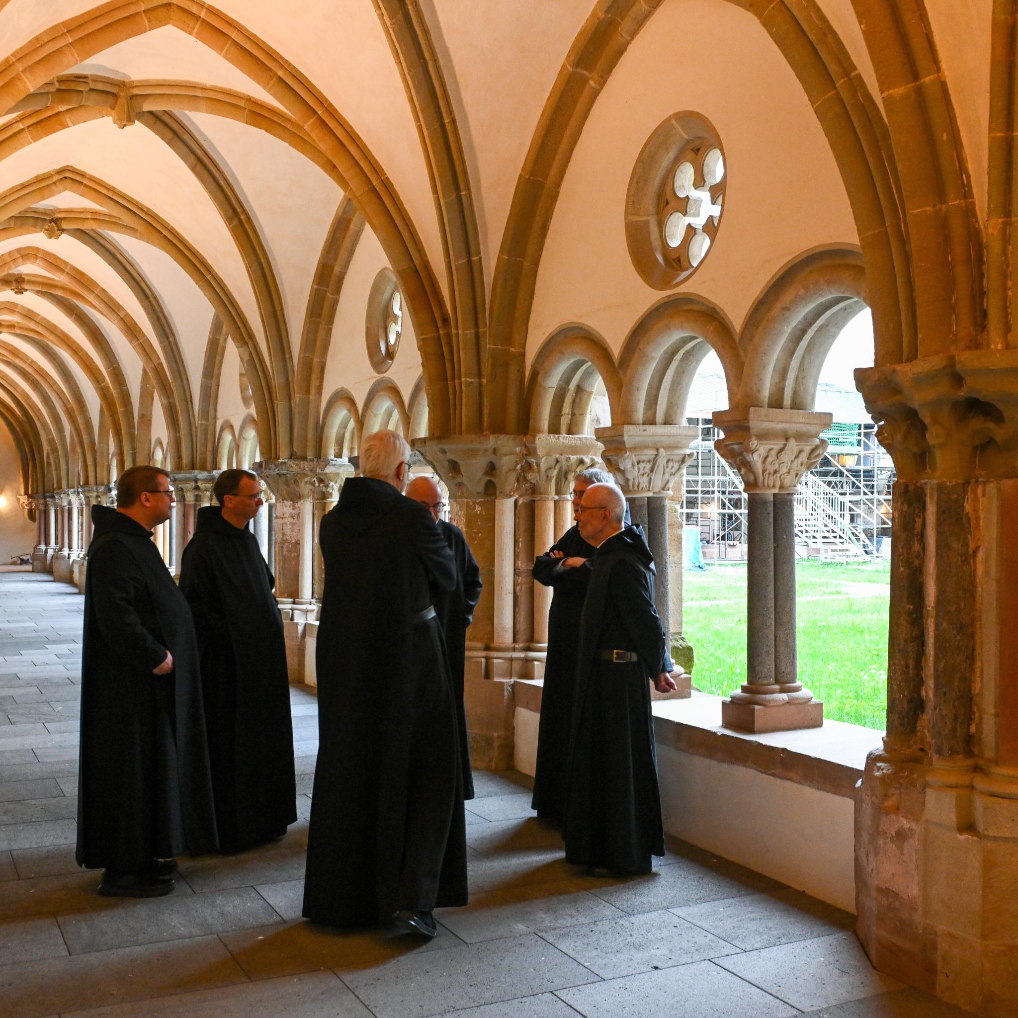 Mönche stehen im Kreuzgang der Benediktinerabtei Sankt Matthias in Trier.