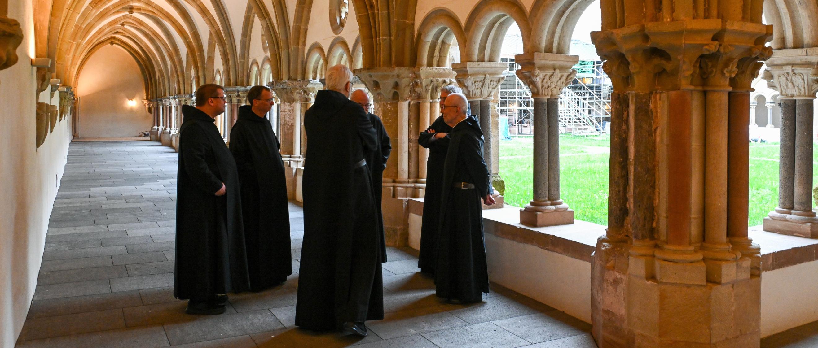 Mönche stehen im Kreuzgang der Benediktinerabtei Sankt Matthias in Trier.