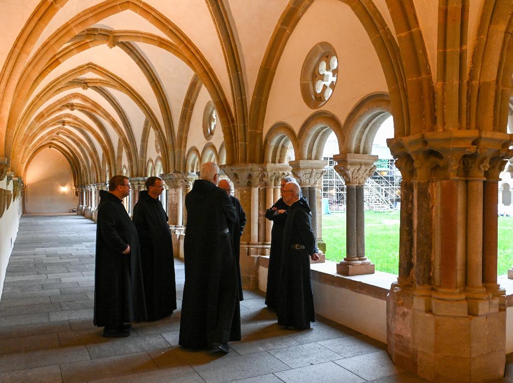 Mönche stehen im Kreuzgang der Benediktinerabtei Sankt Matthias in Trier.