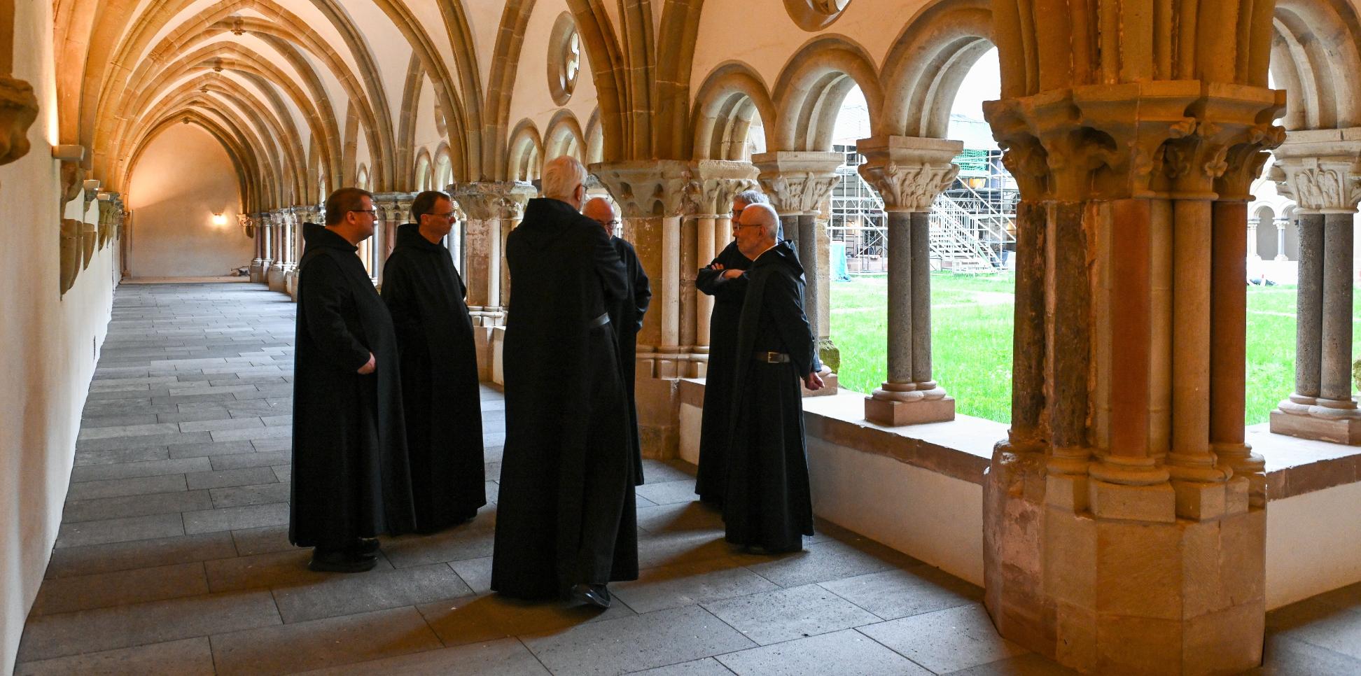Mönche stehen im Kreuzgang der Benediktinerabtei Sankt Matthias in Trier.