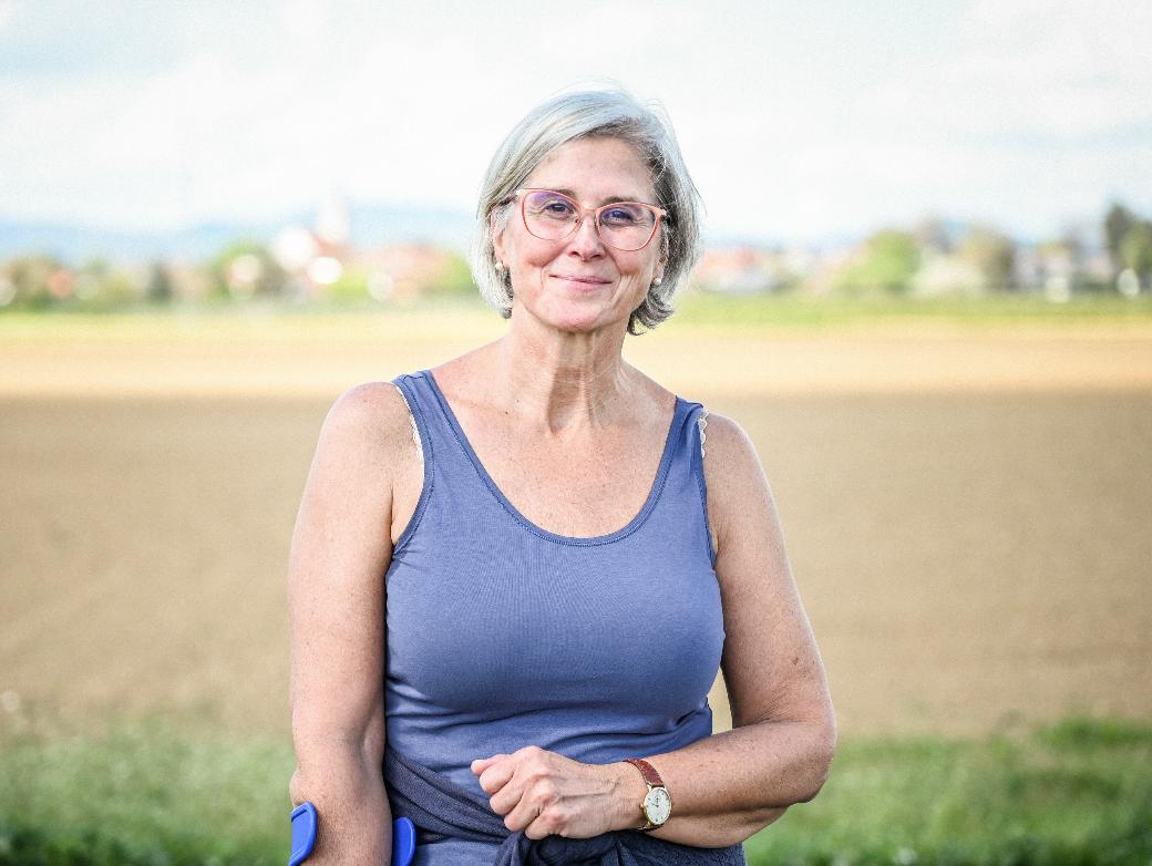Eine lächelnde Frau steht vor einem Feld