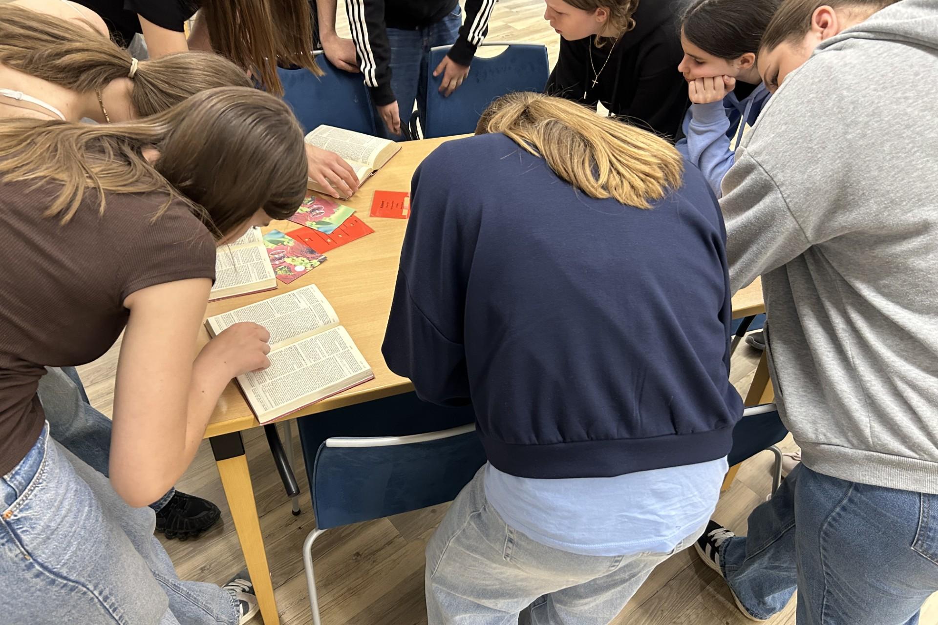 Jugendliche suchen Textstellen in Büchern