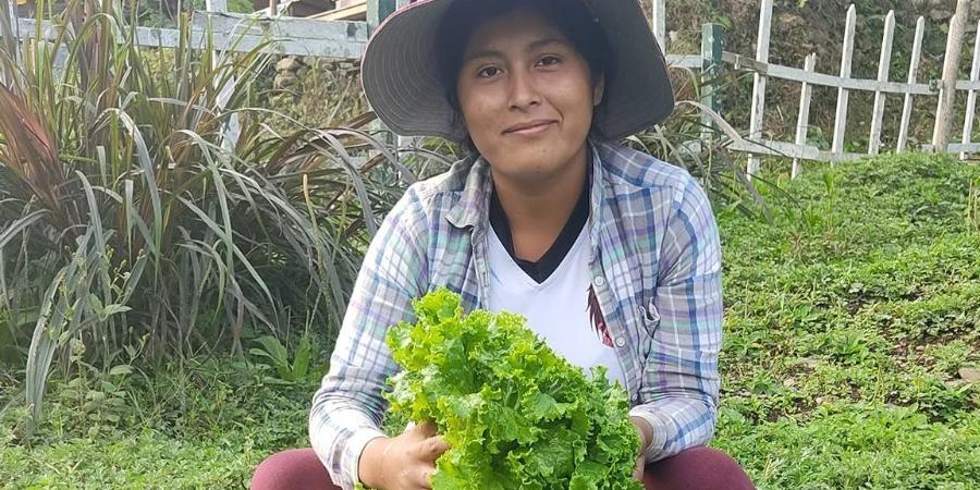 Eine Frau mit Hut lächelt in die Kamera, vor ihr ein Korb mit Salat (c) Diözesanstelle Weltkirche Eine Frau mit Hut lächelt in die Kamera, vor ihr ein Korb mit Salat