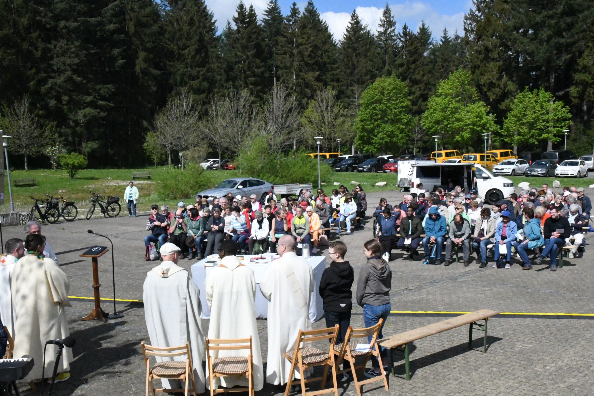 Das Wetter spielt mit beim „Boni-Bus-Pilgerweg“ mit Gottesdienst unter freiem Himmel. Im Hintergrund einige der gelben Boni-Busse.