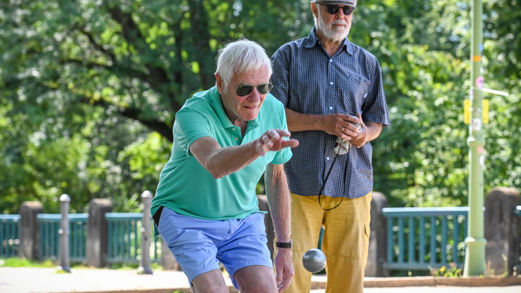 Zwei Männer spielen Boule.