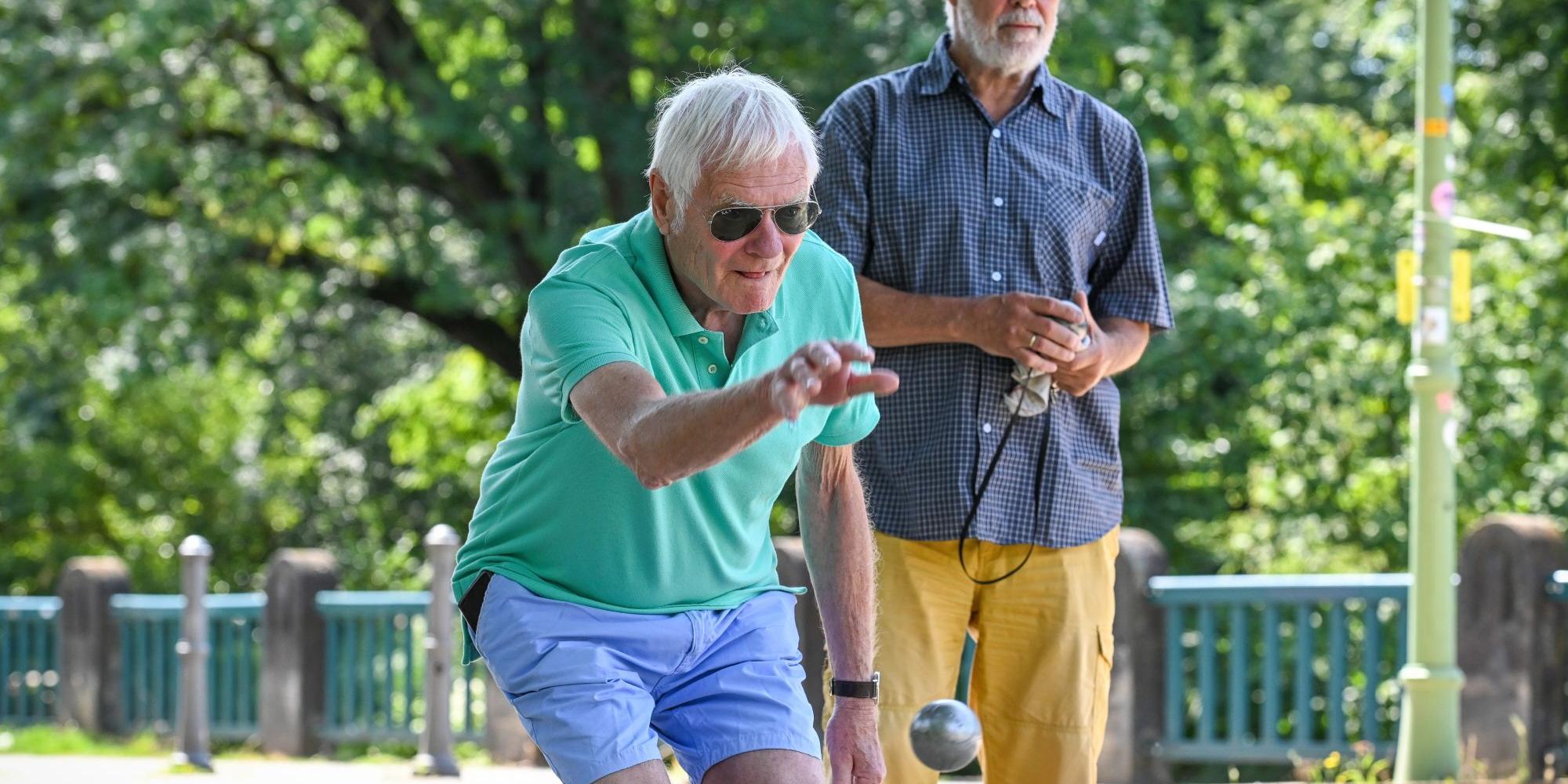 Zwei Männer spielen Boule.
