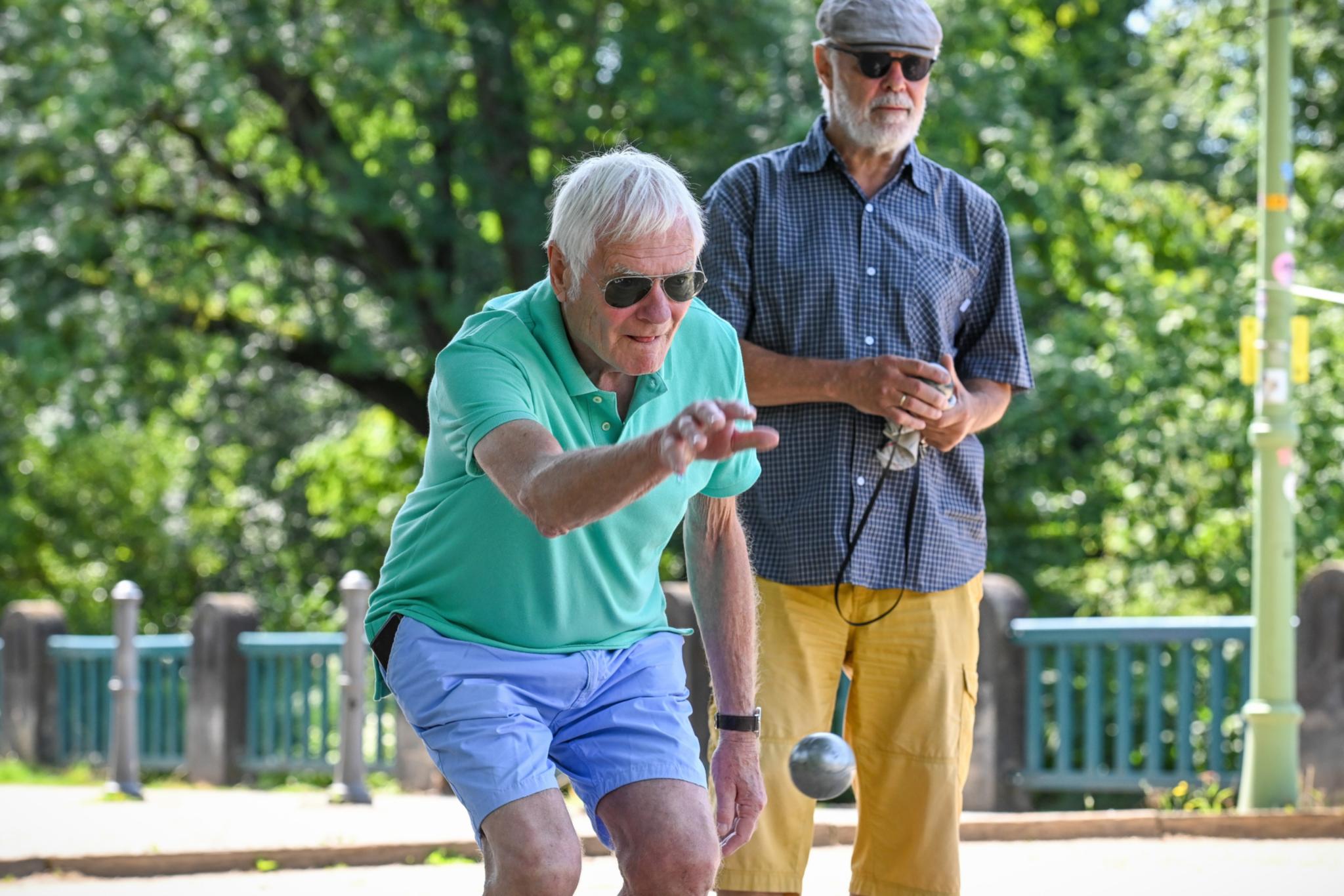 Zwei Männer spielen Boule.