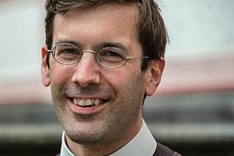 Ein Mann mit Brille lächelt in die Kamera