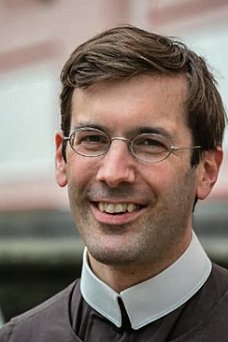 Ein Mann mit Brille lächelt in die Kamera
