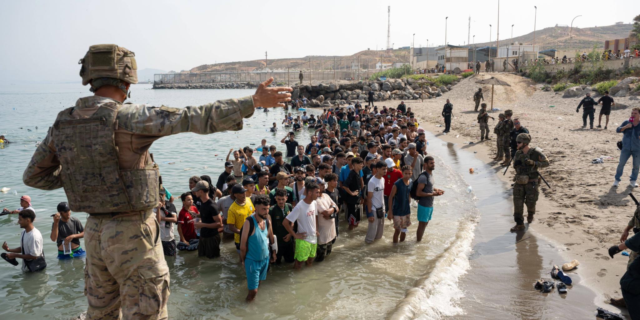 Menschen stehen mit Kleidern im Wasser, im Vordergrund ein Soldat (c) Imago/Zuma Press Wire Menschen stehen mit Kleidern im Wasser, im Vordergrund ein Soldat