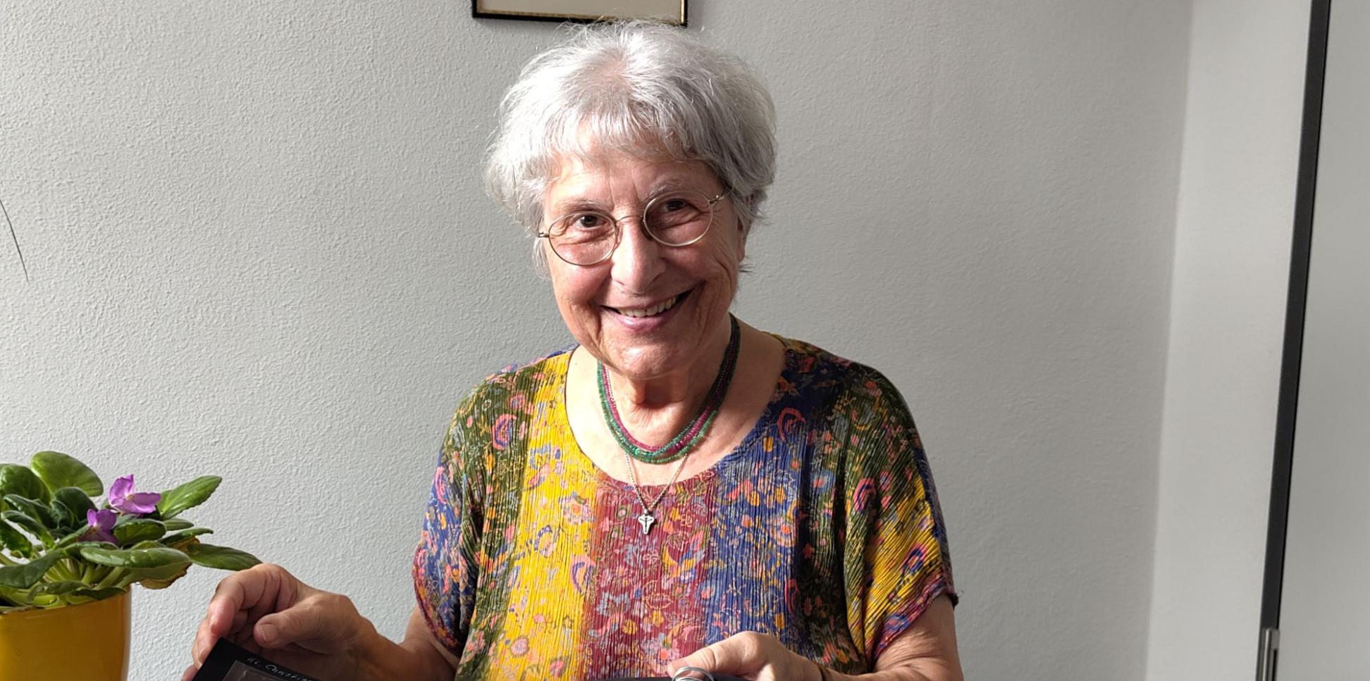 Eine grauhaarige Frau zeigt Bilder in einem Album