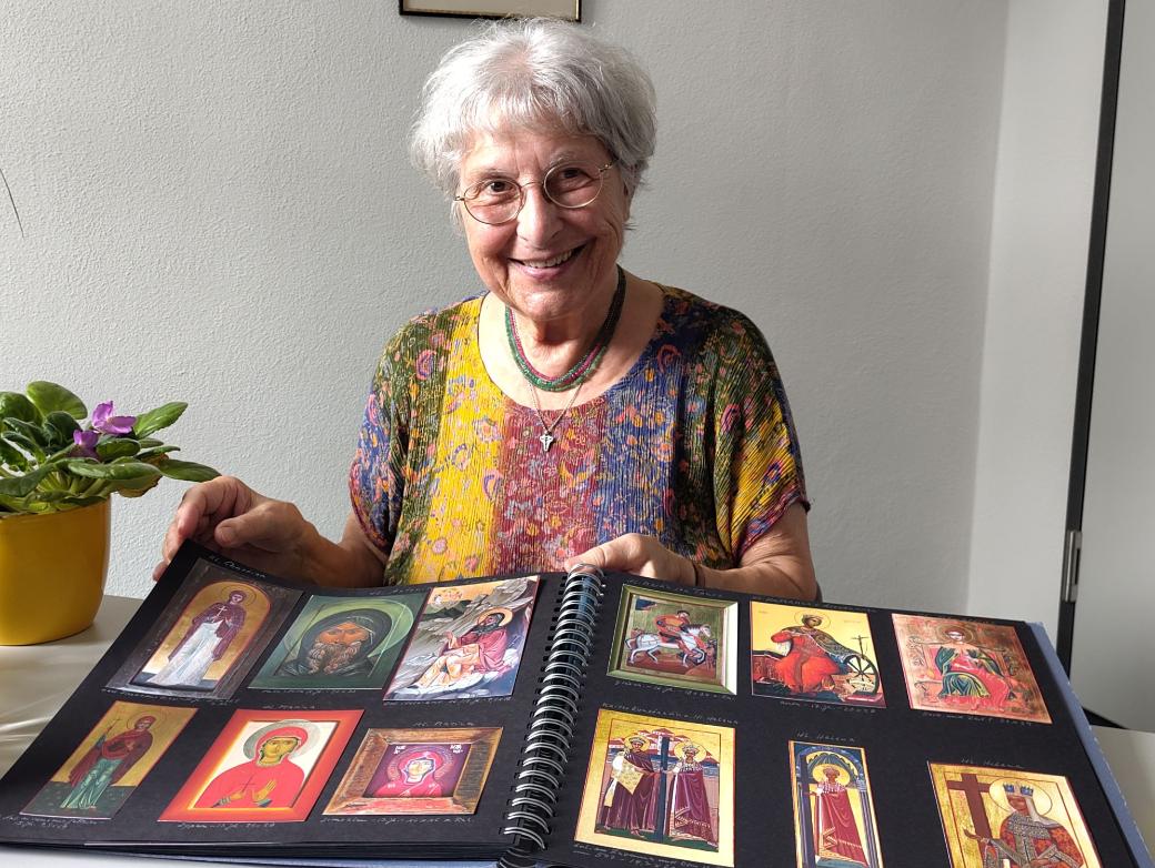 Eine grauhaarige Frau zeigt Bilder in einem Album