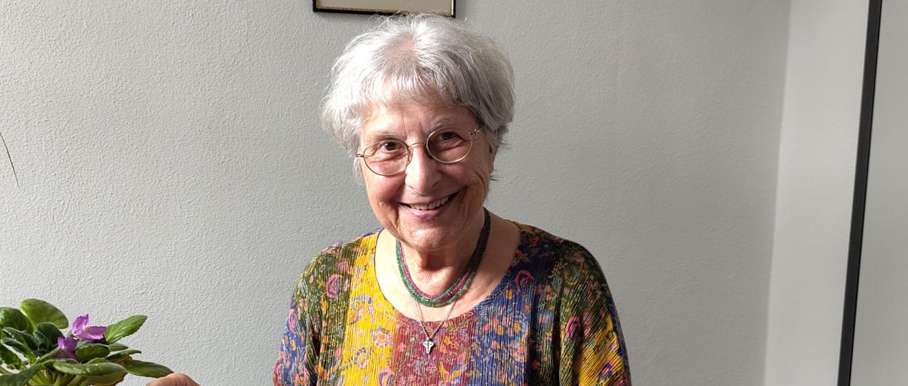 Eine grauhaarige Frau zeigt Bilder in einem Album