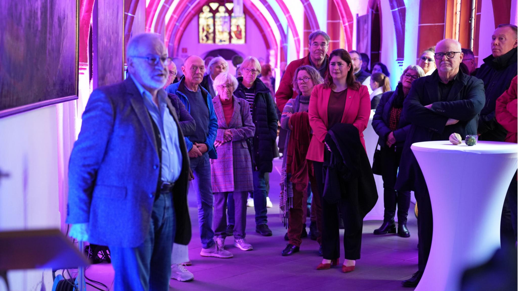 Autor Stefan Kritten (links) erläutert an Gemälden im Kreuzgang die Werke der Barmherzigkeit.