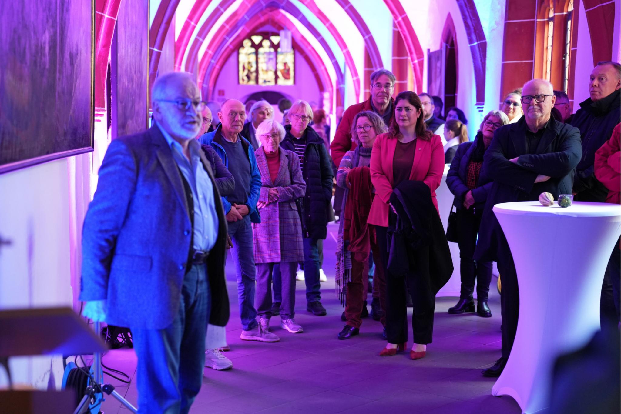 Autor Stefan Kritten (links) erläutert an Gemälden im Kreuzgang die Werke der Barmherzigkeit.