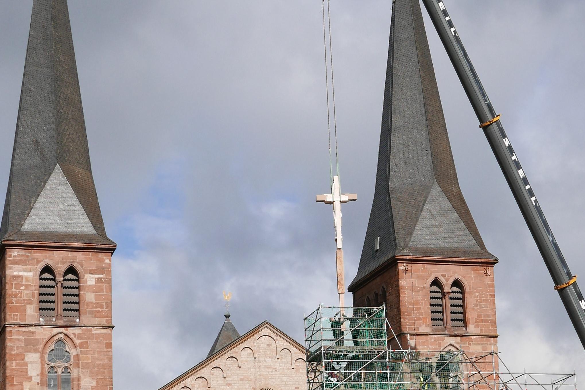 Zum Transport sicher verpackt in Folie und Holz hängt das Kreuz über der Heimtumskammer noch am Kran.
