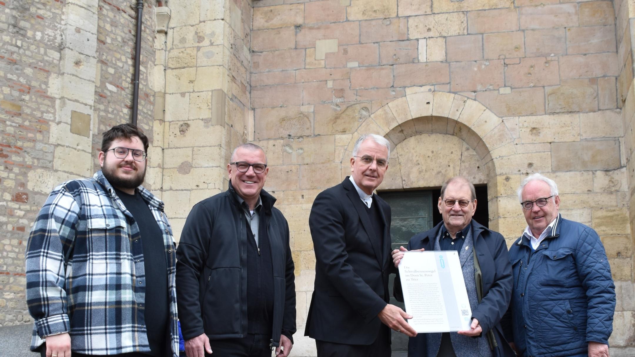 Fünf Männer vor dem Trierer Dom lächeln in die Kamera