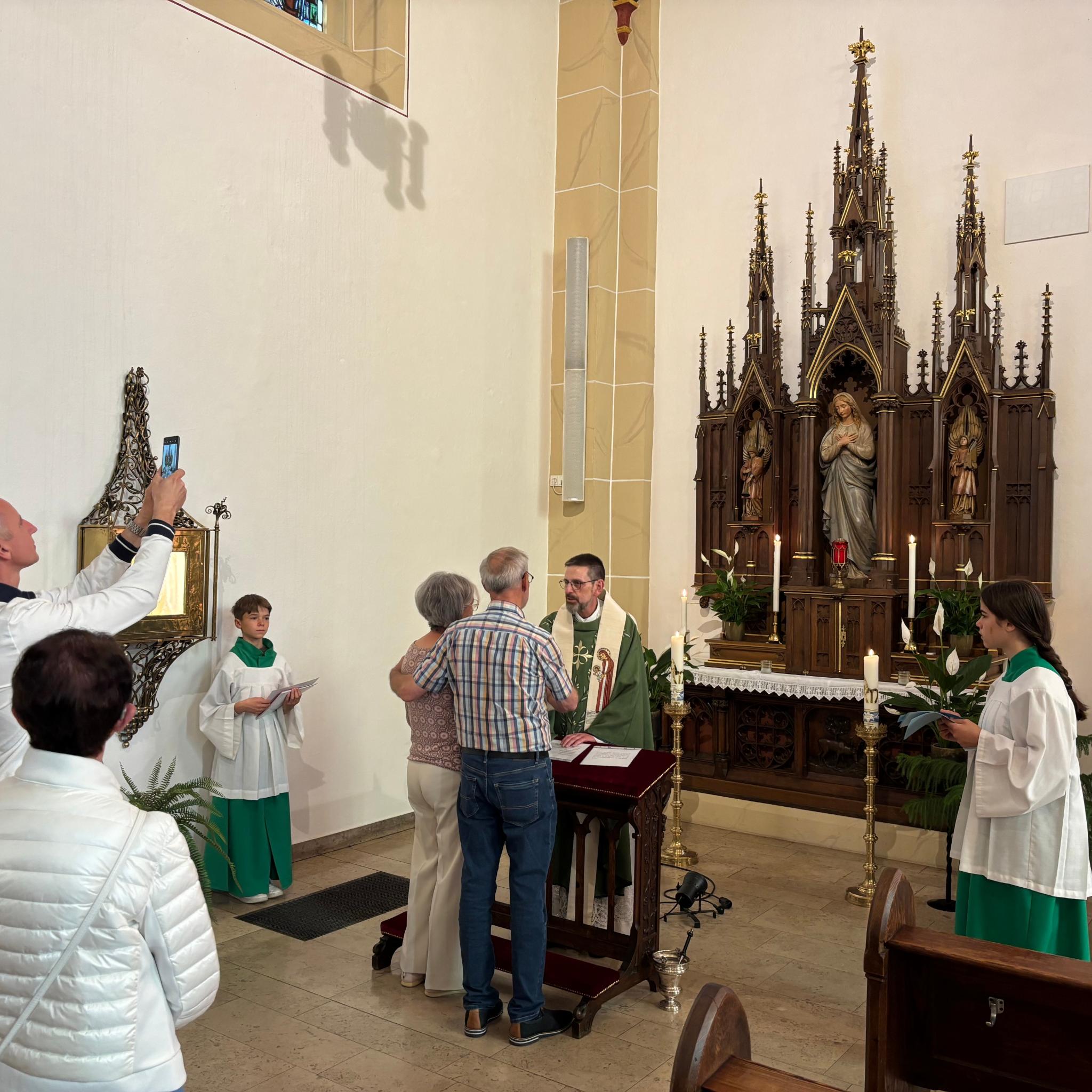 Ein Priester segnet ein Ehepaar