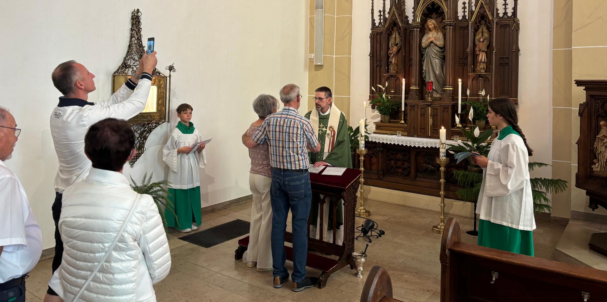 Ein Priester segnet ein Ehepaar