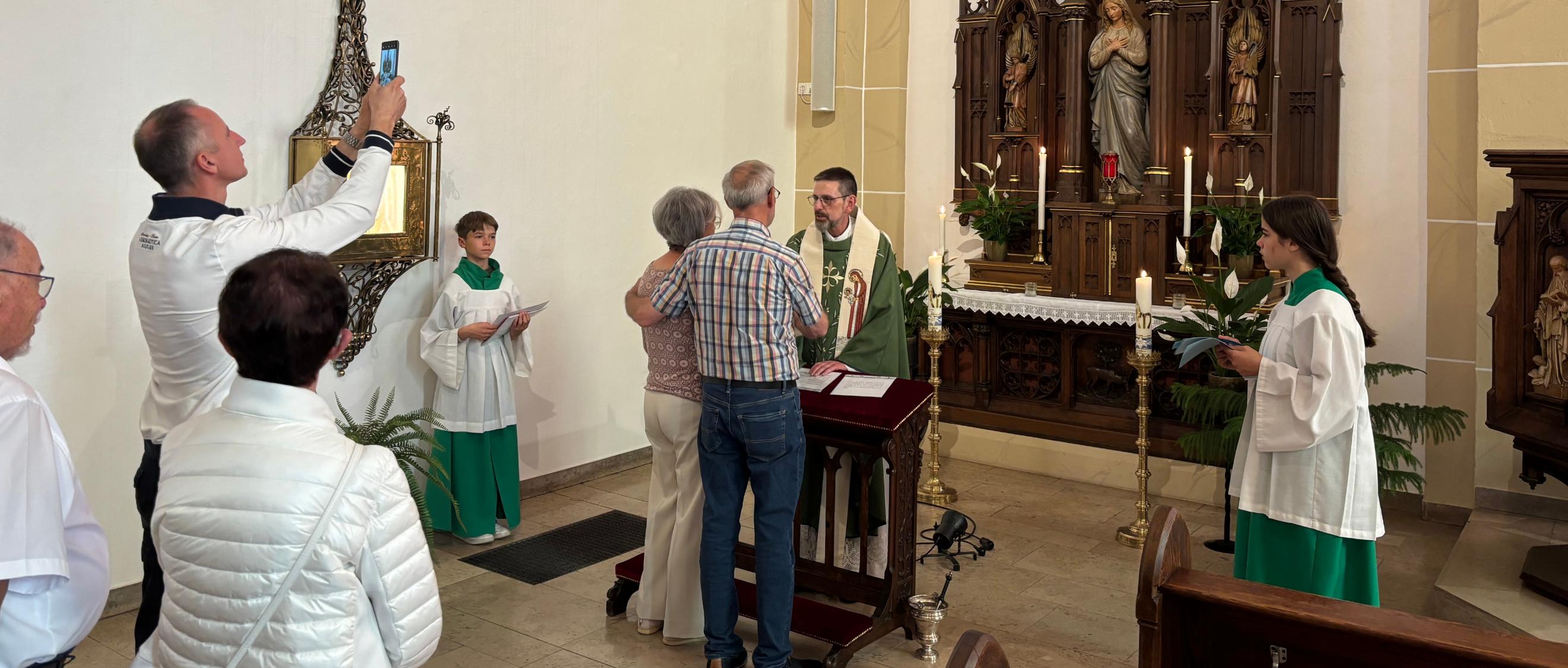 Ein Priester segnet ein Ehepaar