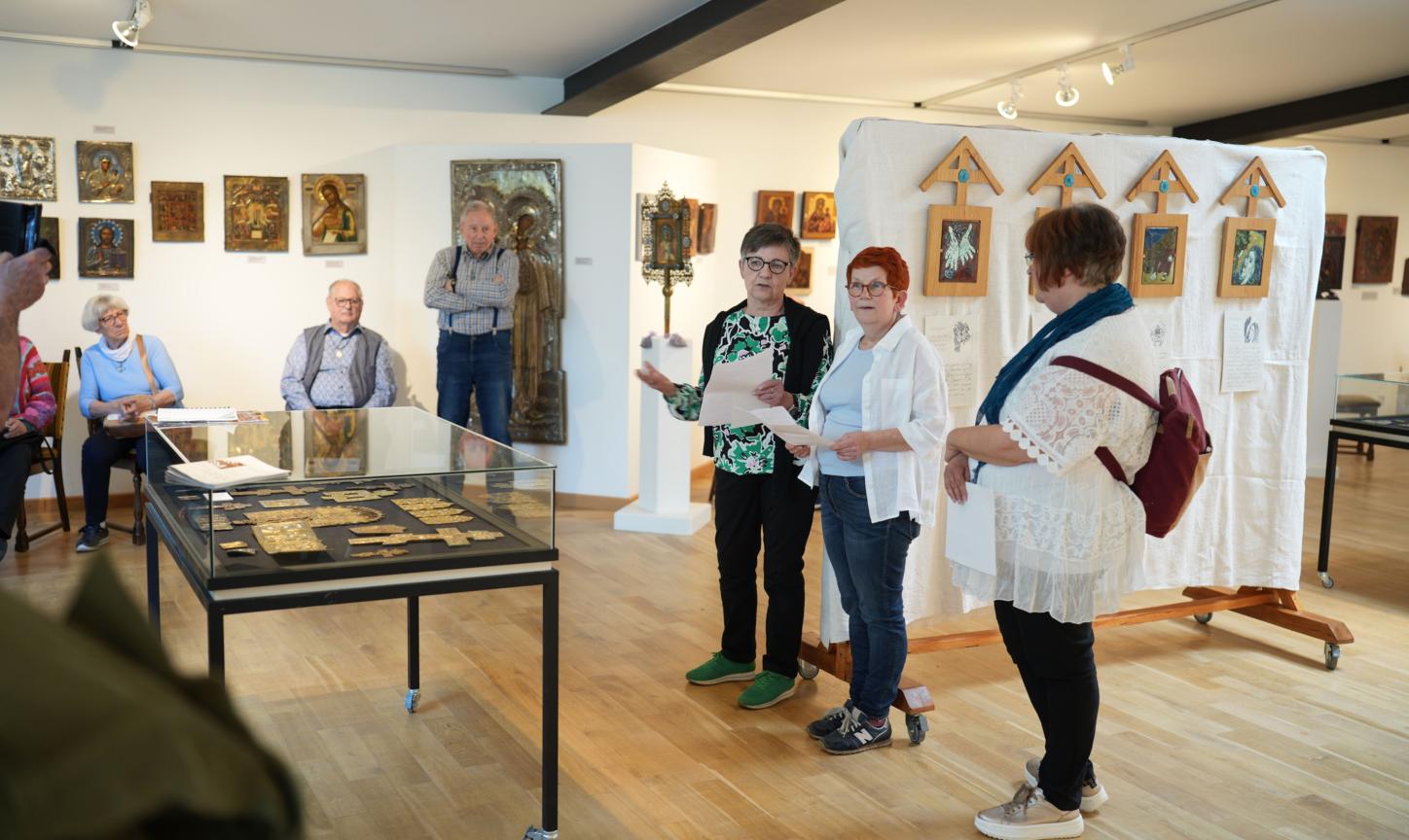 Die Emaille-Künstlerin Isabelle Mathis und die CKI-Vorsitzende Mechthild Häusler (Zweite und Dritte von rechts) eröffnen  die Kreuzweg-Ausstellung