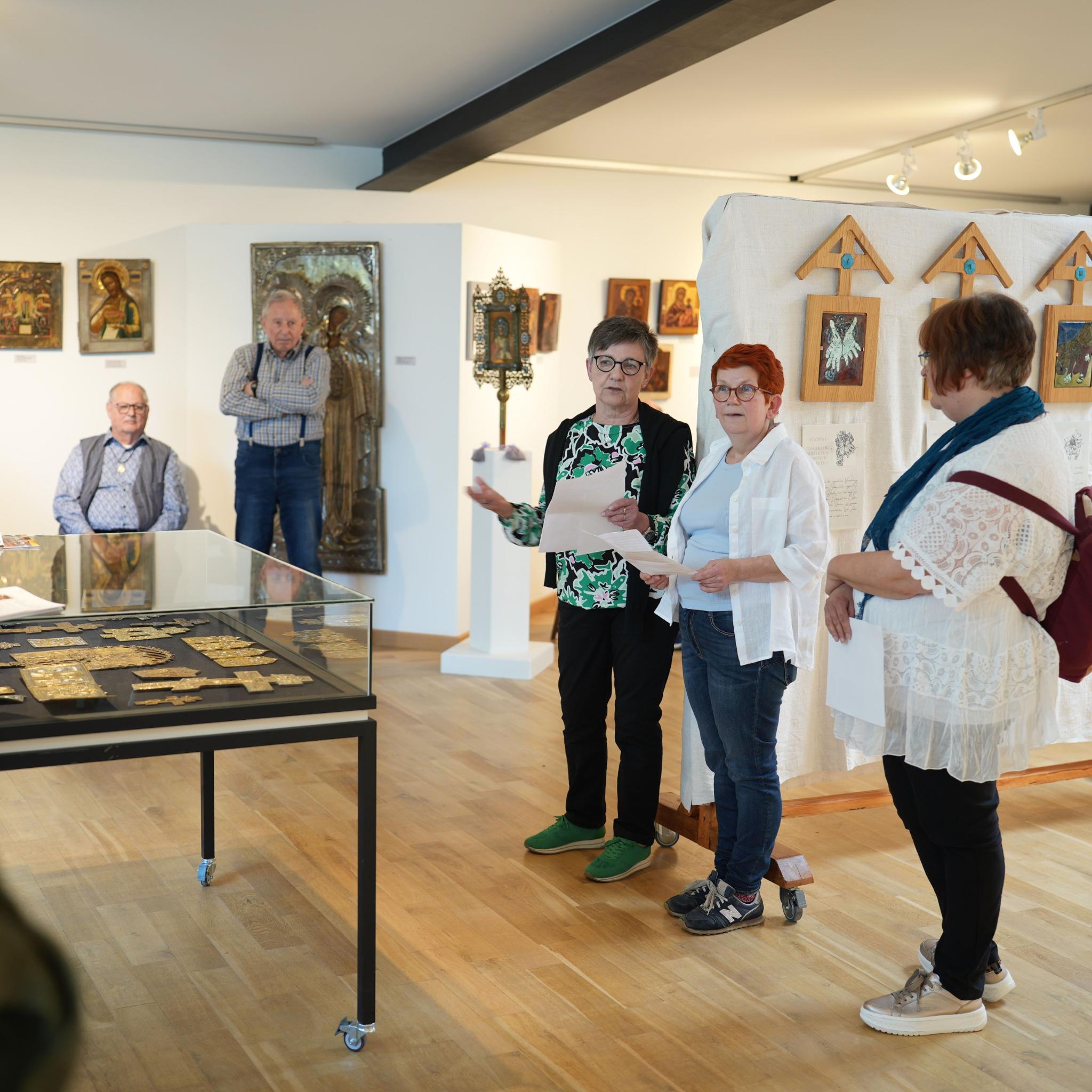 Die Emaille-Künstlerin Isabelle Mathis und die CKI-Vorsitzende Mechthild Häusler (Zweite und Dritte von rechts) eröffnen  die Kreuzweg-Ausstellung