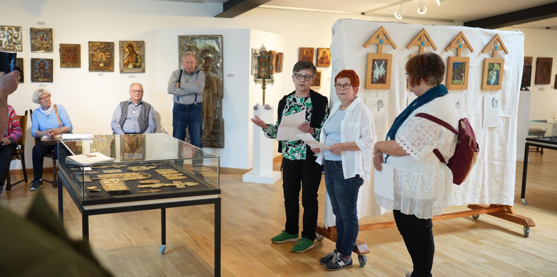 Die Emaille-Künstlerin Isabelle Mathis und die CKI-Vorsitzende Mechthild Häusler (Zweite und Dritte von rechts) eröffnen  die Kreuzweg-Ausstellung