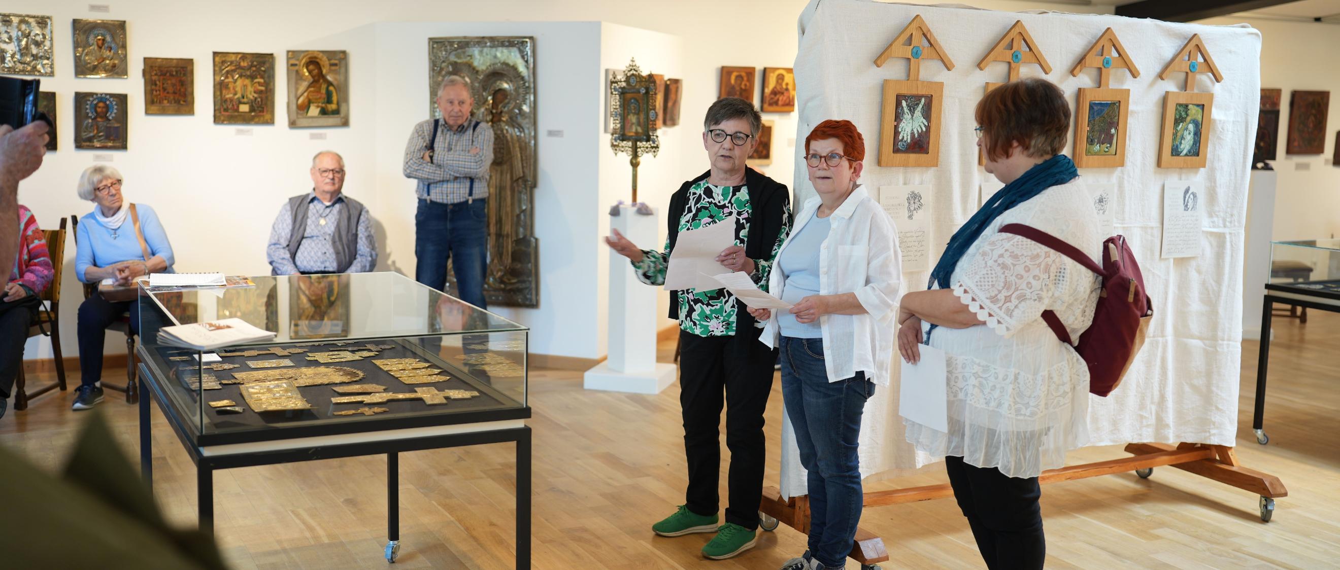 Die Emaille-Künstlerin Isabelle Mathis und die CKI-Vorsitzende Mechthild Häusler (Zweite und Dritte von rechts) eröffnen  die Kreuzweg-Ausstellung
