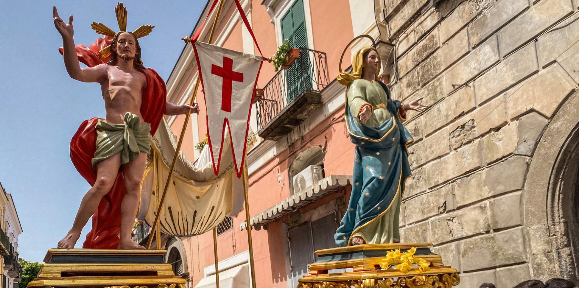 Kostümierte Männer, Mitglieder der Erzbruderschaft Santa Maria Visitapoveri, tragen Statuen von Jesus und Maria bei einer Prozession an Ostersonntag 2025 auf der Insel Ischia in Italien.