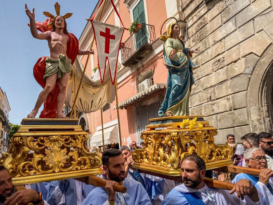 Kostümierte Männer, Mitglieder der Erzbruderschaft Santa Maria Visitapoveri, tragen Statuen von Jesus und Maria bei einer Prozession an Ostersonntag 2025 auf der Insel Ischia in Italien.
