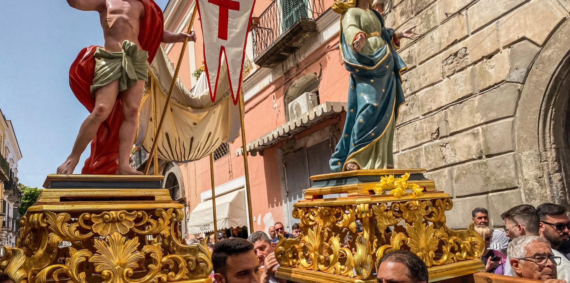 Kostümierte Männer, Mitglieder der Erzbruderschaft Santa Maria Visitapoveri, tragen Statuen von Jesus und Maria bei einer Prozession an Ostersonntag 2025 auf der Insel Ischia in Italien.
