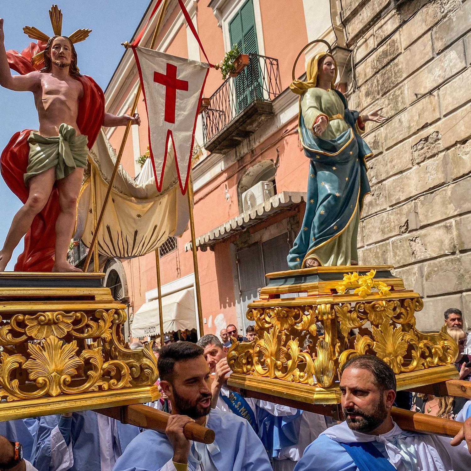 Kostümierte Männer, Mitglieder der Erzbruderschaft Santa Maria Visitapoveri, tragen Statuen von Jesus und Maria bei einer Prozession an Ostersonntag 2025 auf der Insel Ischia in Italien.