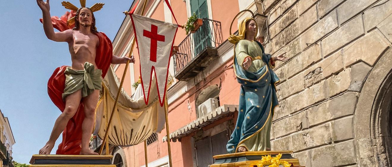 Kostümierte Männer, Mitglieder der Erzbruderschaft Santa Maria Visitapoveri, tragen Statuen von Jesus und Maria bei einer Prozession an Ostersonntag 2025 auf der Insel Ischia in Italien.