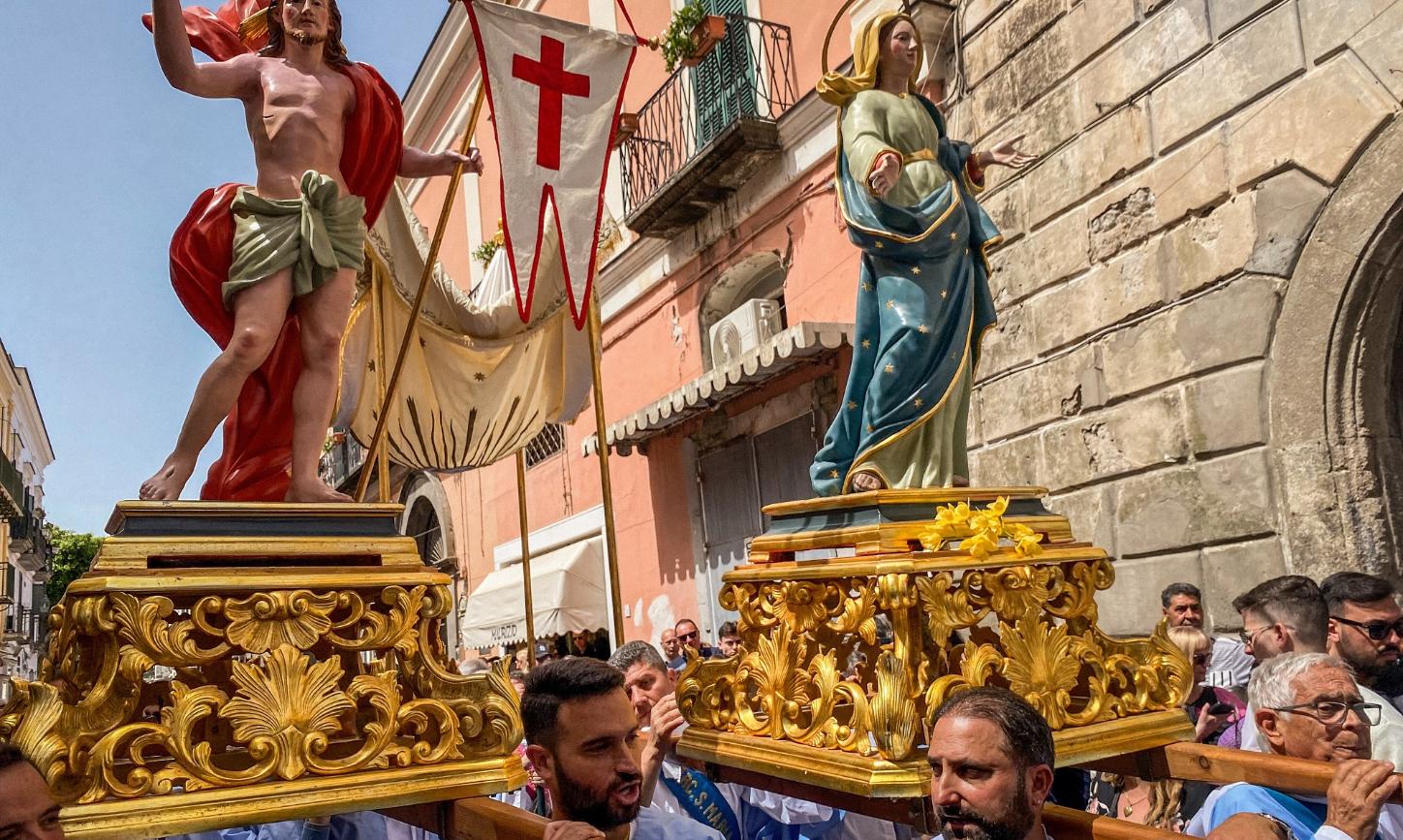 Kostümierte Männer, Mitglieder der Erzbruderschaft Santa Maria Visitapoveri, tragen Statuen von Jesus und Maria bei einer Prozession an Ostersonntag 2025 auf der Insel Ischia in Italien.