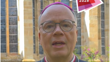 Ein Mann in Soutane und Brille schaut in die Kamera