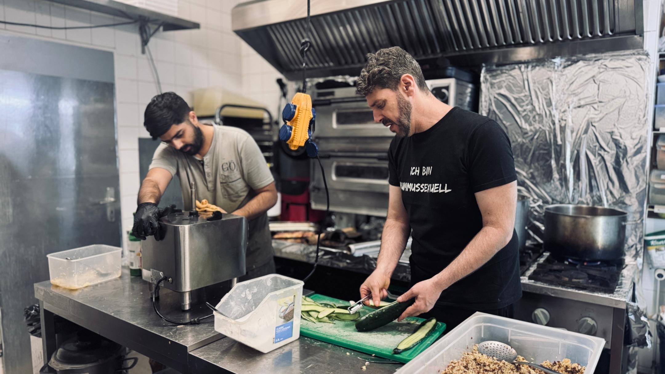 Zwei Köche arbeiten miteinander in einer Gastroküche