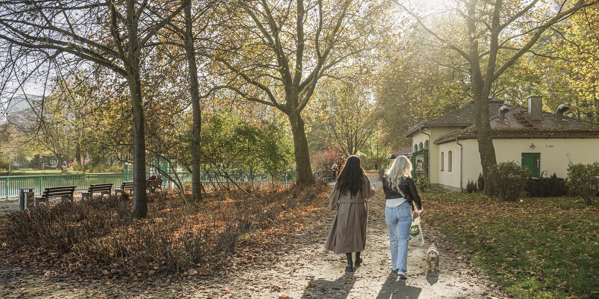 Zwei Frauen mit Hund bei Spaziergang.