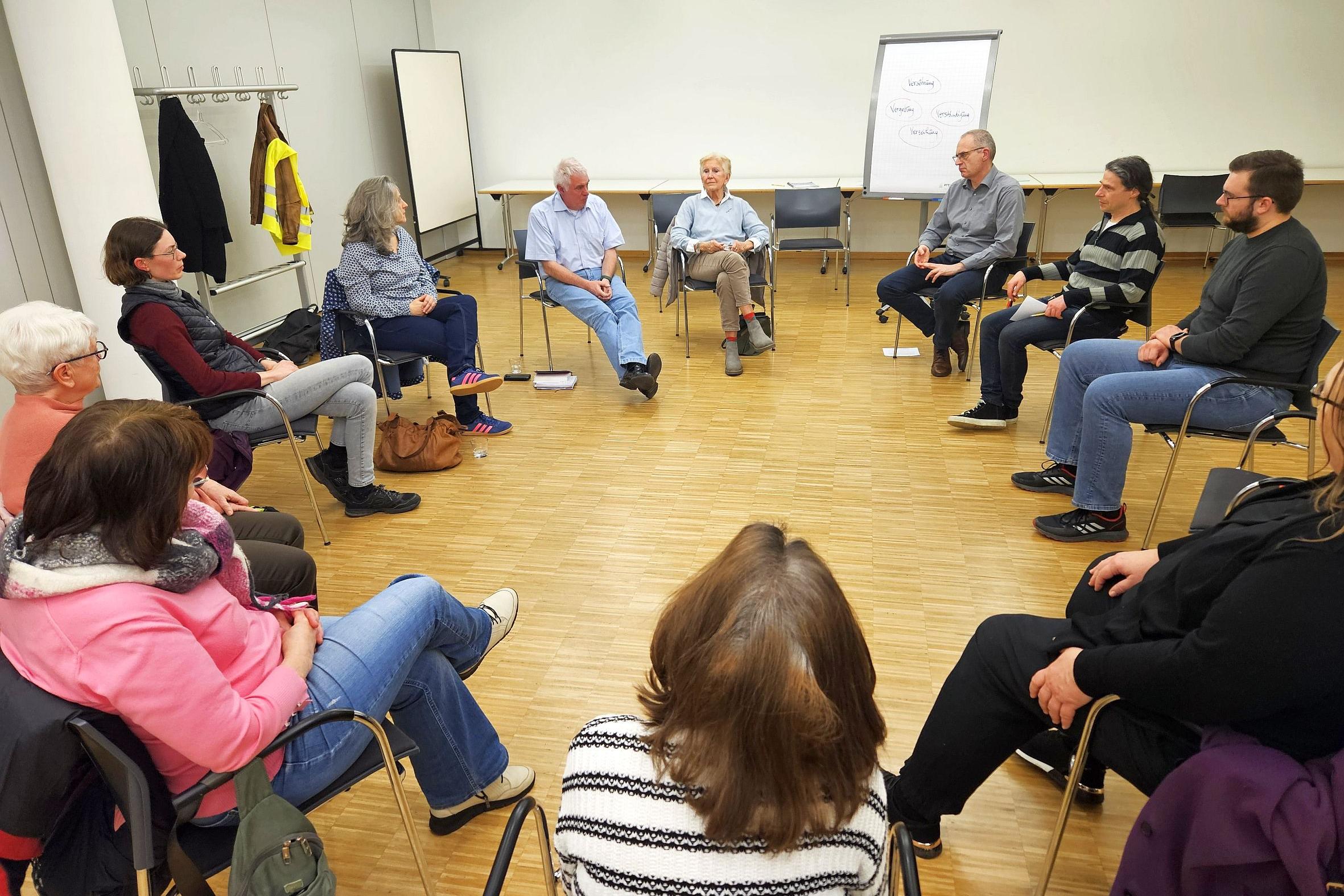 Mehrere Menschen sitzen im Kreis und tauschen sich aus