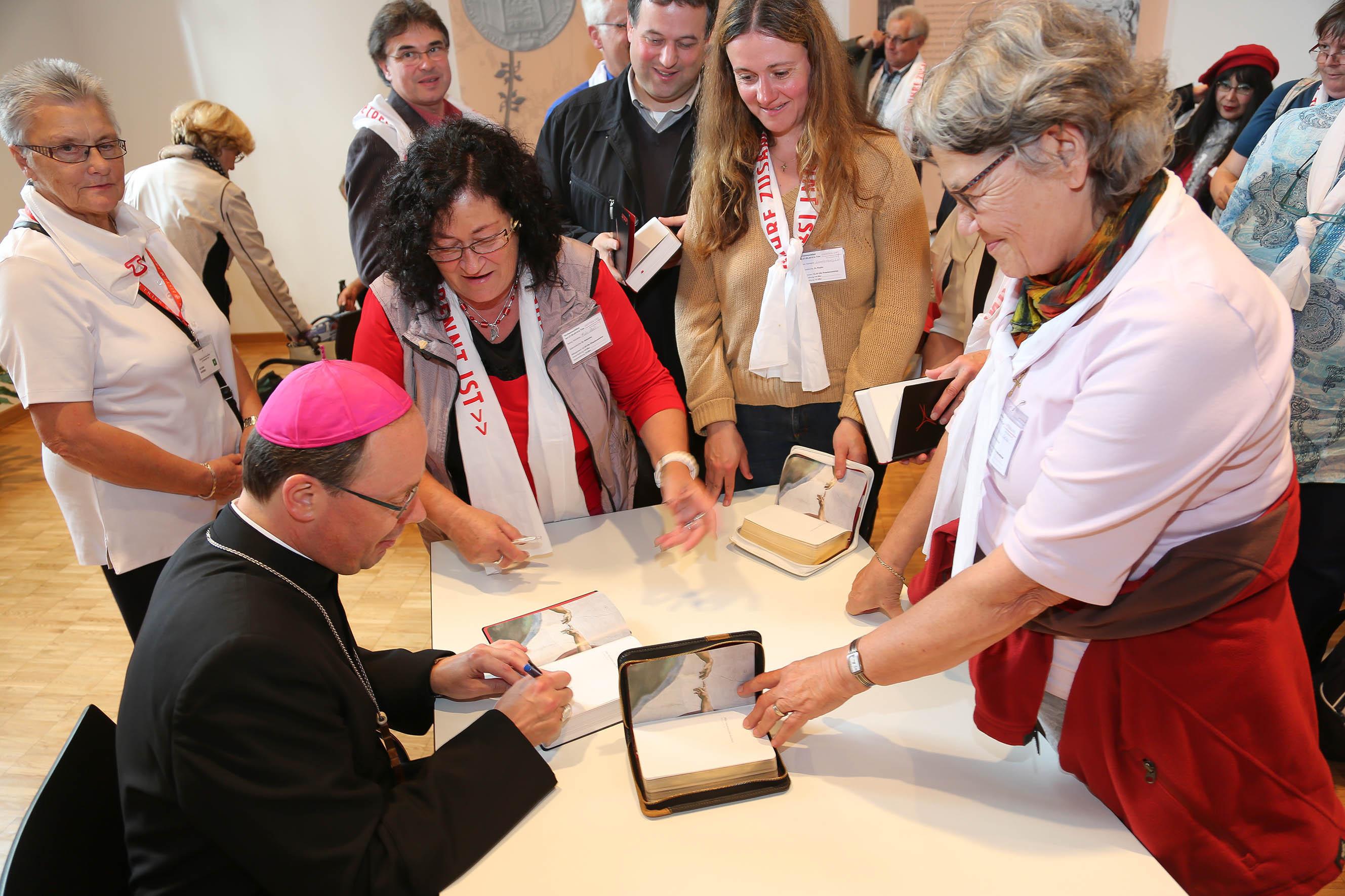 Bischof Dr. Stephan Ackermann signiert Exemplare des neuen „Gotteslob“ in der Dom-Information.
