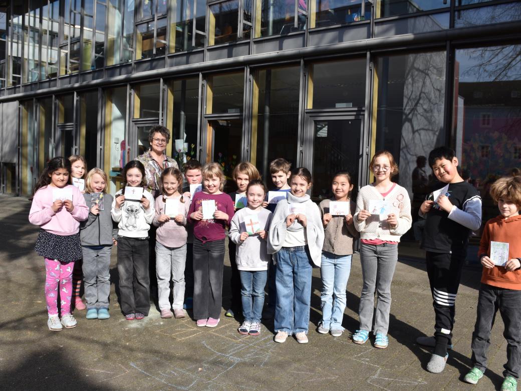 Eine Gruppe Grundschulkinder blickt lächelnd in die Kamera